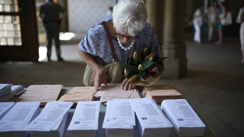 A woman selects her ballots to vote at a polling station in Barcelona, Spain (Joan Mateu Parra/AP/PA)