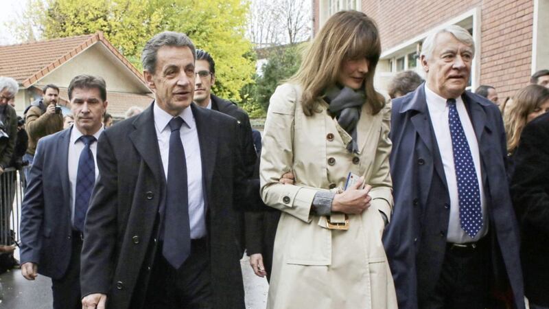 Former French President Nicolas Sarkozy and his wife Carla Bruni-Sarkozy leave the polling station after casting their votes for the conservative primary election, in Paris. Picture by Thibault Camus, Associated Press