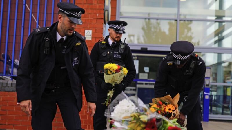 Police officers leave flowers outside Croydon Custody Centre in south London where a police officer was shot by a man who was being detained in the early hours of this morning. Picture by Aaron Chown, Press Association