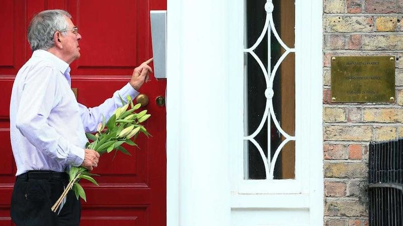 A member of the public arrives with flowers at the French embassy in Merrion Square, Dublin yesterday. Picture by Brian Lawless/PA 