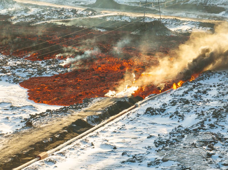 Lava hitting a hot water pipeline and flowing onto the road leading to the Blue Lagoon, in Grindavik, Iceland (Marco Di Marco/AP)