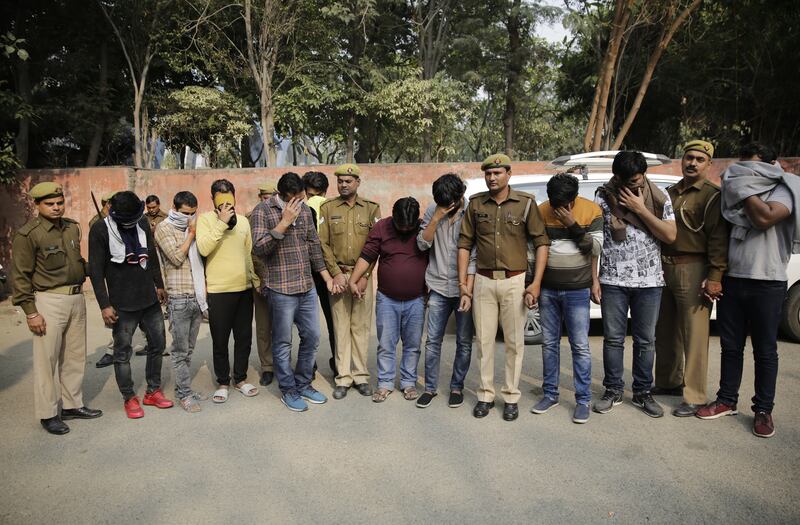 Alleged fraudsters are presented before media at a police station in Noida, a suburb of New Delhi