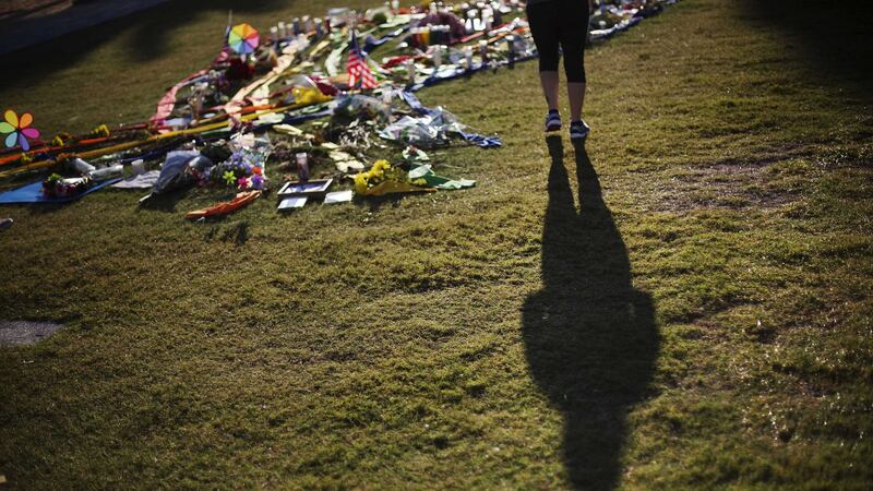 A woman casts a shadow while visiting a makeshift memorial downtown to the victims of the Pulse nightclub mass shooting in Orlando, Florida. Picture by David Goldman, Associated Press&nbsp;