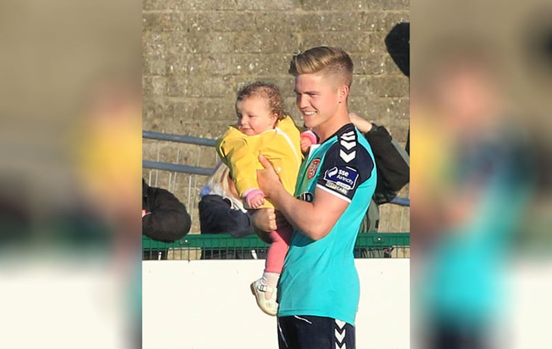 &nbsp;Rionaghac-Ann in the arms of her uncle Joshua Daniels at a Derry FC match earlier this year. Picture by Margaret McLaughlin