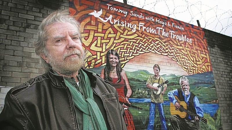 Folk singer Tommy Sands at a mural in Belfast which was painted in his honour Picture: Hugh Russell 