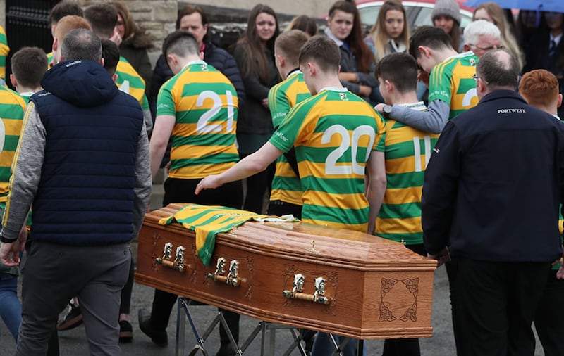 Edendork GAC players pictured with the coffin of Connor Currie outside St Malachy's Church. Picture by Brian Lawless, Press Association