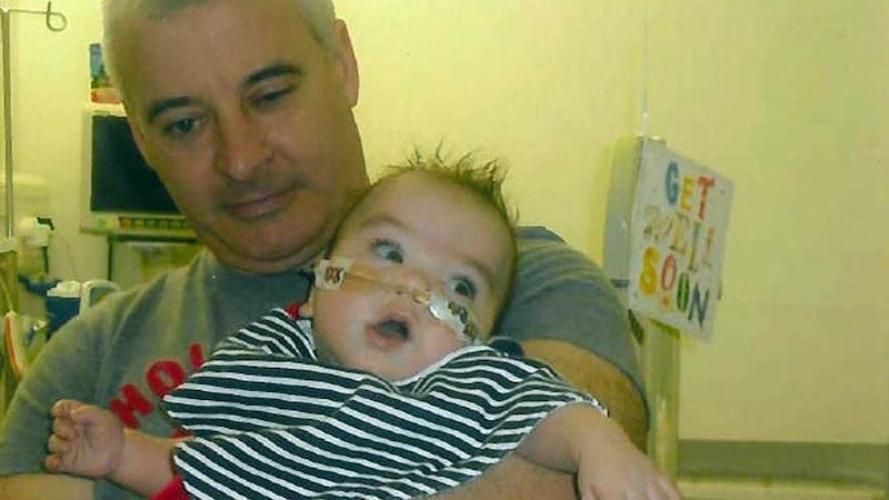 Kevin McGuigan, who was shot dead in east Belfast in August, pictured with his grandson Ollie who was in hospital in 2011 