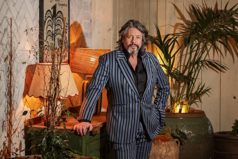 Laurence Llewelyn Bowen standing beside greenery and lamps