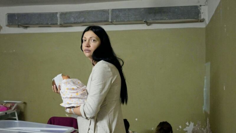 A woman holds her newborn child in the basement of a maternity hospital in Kyiv. The basement has been converted into a medical ward and used as a bomb shelter in an attempt to offer some means of protection from Russian attacks. Picture by AP Photo/Efrem Lukatsky. 
