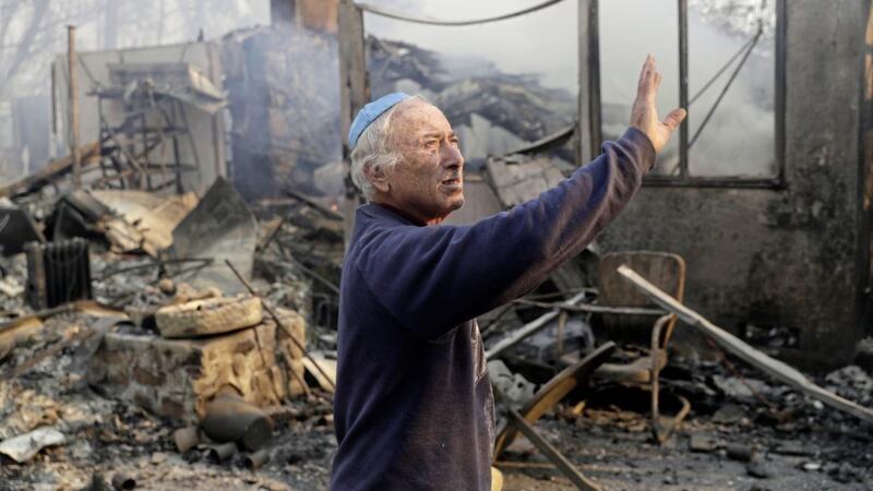 John Honigsfeld surveys the damage to a neighbour's property after a wildfire swept through it on Saturday <br /><br />Picture by Marcio Jose Sanchez/AP