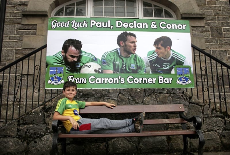 Reoin Logue beside a poster in Ederney of the three Fermanagh  players from the village. Picture by Ann McManus 