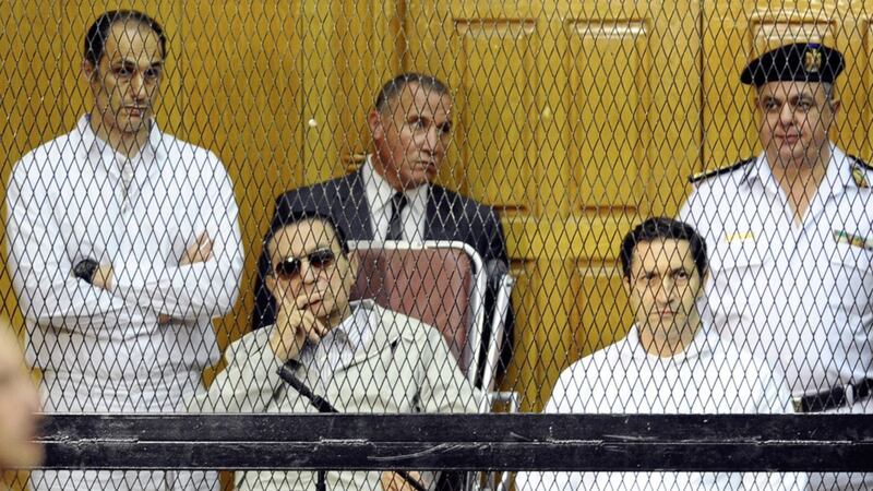 Former Egyptian president Hosni Mubarak, seated centre left, and his two sons, Gamal Mubarak, left, and Alaa Mubarak attend a hearing in a courtroom in Cairo 