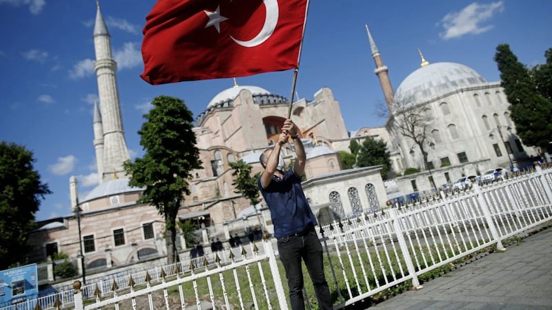A man waves a Turkish flag outside Hagia Sophia - a former cathedral-turned-mosque that became a museum in 1934 - in Istanbul. Turkey&#39;s highest administrative court ruled last Friday that the 6th century Byzantine building could be turned back into a Muslim house of worship. Pope Francis said he was &quot;deeply pained&quot; at the decision. Picture by AP Photo/Emrah Gurel 