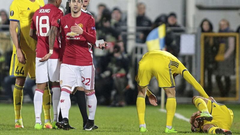 Manchester United&#39;s goalscorer Henrikh Mkhitaryan receives a yellow card as Rostov&#39;s Fedor Kudryashov lies on the ground after being injured during the Europa League round of 16 first leg match 