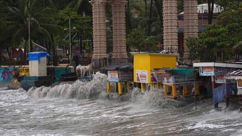Waves hit stalls on the beach during high tide on the Arabian Sea coast in Mumbai, India (Rajanish Kakade/AP)