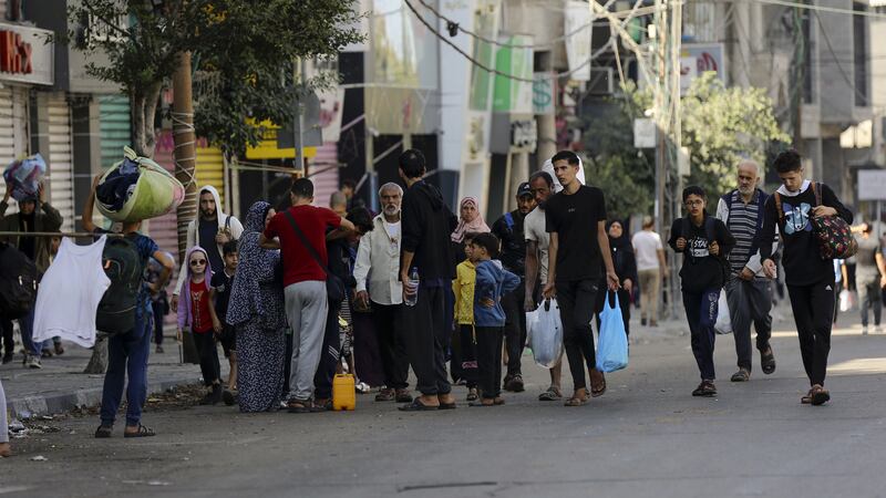 Palestinians walk in the al-Rimal area of Gaza City (AP)