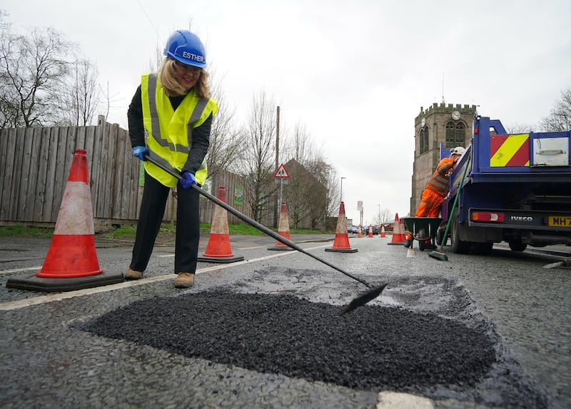 Minister without Portfolio Esther McVey helps repairs potholes in Leigh in Greater Manchester