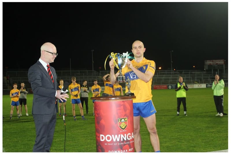 St Paul's, Holywood captain Daniel Eastwood receives the Down Junior Championship trophy from Down chairman Jack Devaney. Pictures courtesy of Steven Kane