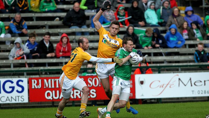 Antrim's Mark Sweeney, aided by Kieran McGourty, challenges Fermanagh's Declan McCusker during the Saffrons' Ulster Championship defeat at Brewster Park last month&nbsp;