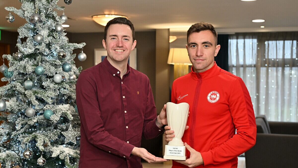 Joe Thomson receives his Dream Spanish Homes Player of the Month award from NIFWA Chairperson Michael Clarke.