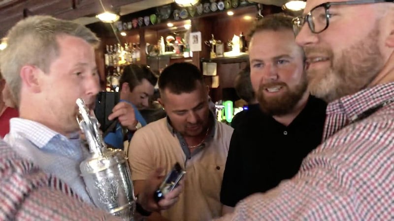 Punters in Dublin's Boar's Head have their picture taken with the Claret Jug after Shane Lowry arrived with friends and supporters to celebrate winning the Open. Picture by Aoife Moore/PA Wire