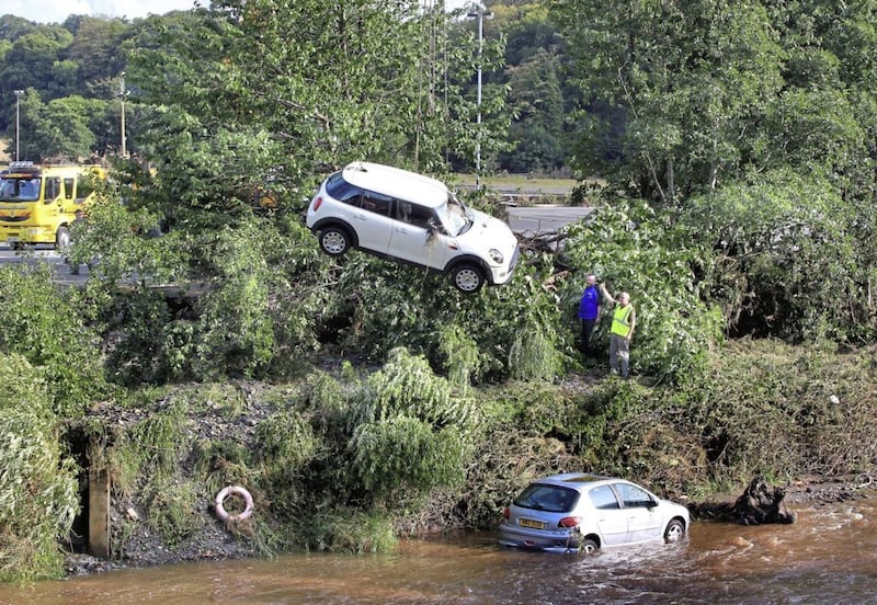 Cars that were swept into the River Faughan at Drumahoe on the outskirts of Derry during severe rain and storms in the north west area of N-Ireland are removed on Wednesday night. Picture Margaret McLaughlin 23-8-17. 