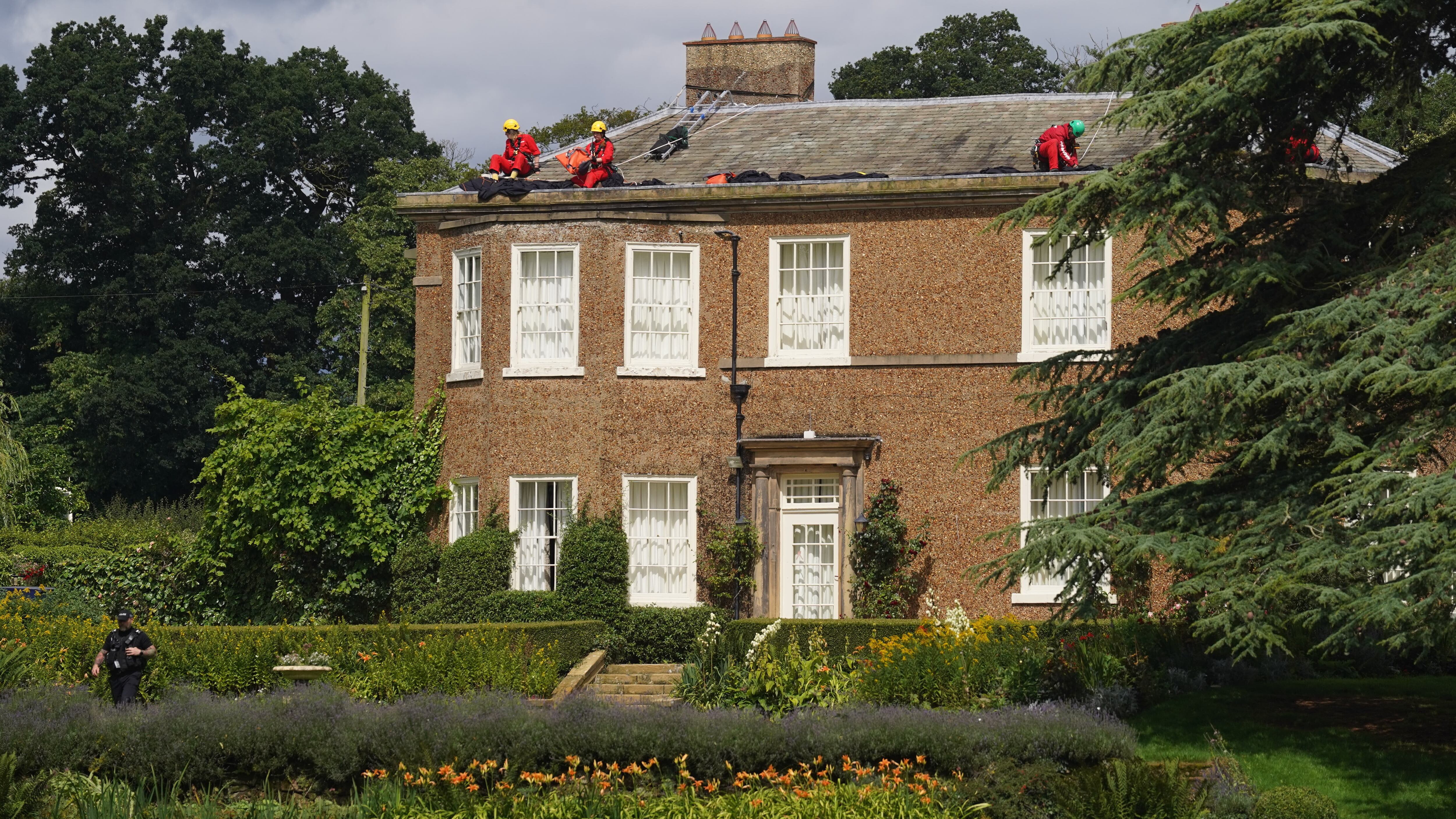 Activists moving fabric on the roof of Prime Minister Rishi Sunak’s house in Richmond, North Yorkshire after covering it in black fabric in protest at his backing for expansion of North Sea oil and gas drilling. Picture date: Thursday August 3, 2023.