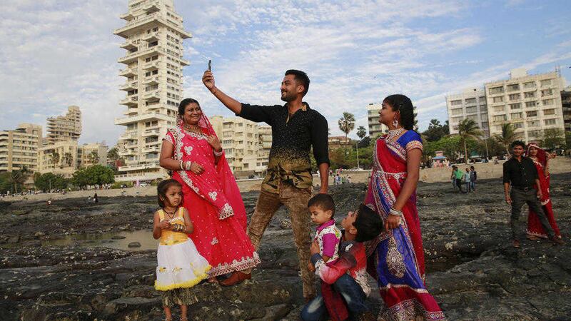An Indian family takes a selfie along Mumbai&#39;s coastline 
