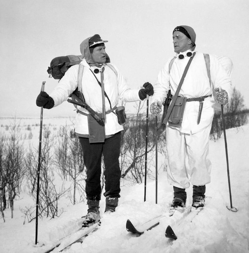 Richard Harris (left) and Kirk Douglas plough through heavy snow for the war film The Heroes of Telemark (PA)