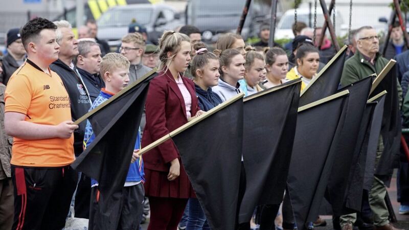 Children hold up black flags at Monday evening&#39;s Sinn F&eacute;in gathering at Raymond McCreesh play park in Newry. Picture: Cliff Donaldson 