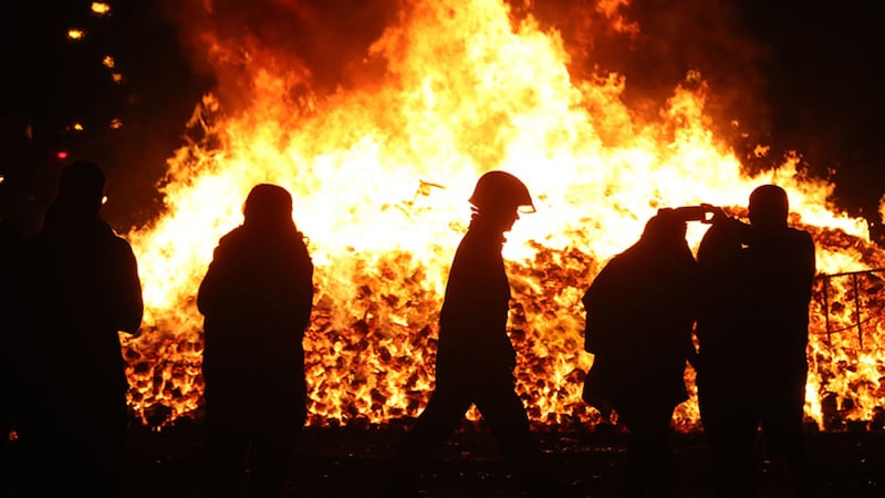 A firefighter attends to an 11th night Bonfire in the Sandy Row area of Belfast&nbsp;