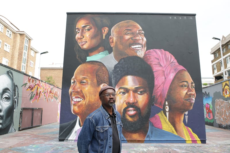 Neequaye Dreph standing in front of the mural at the Stockwell Hall of Fame
