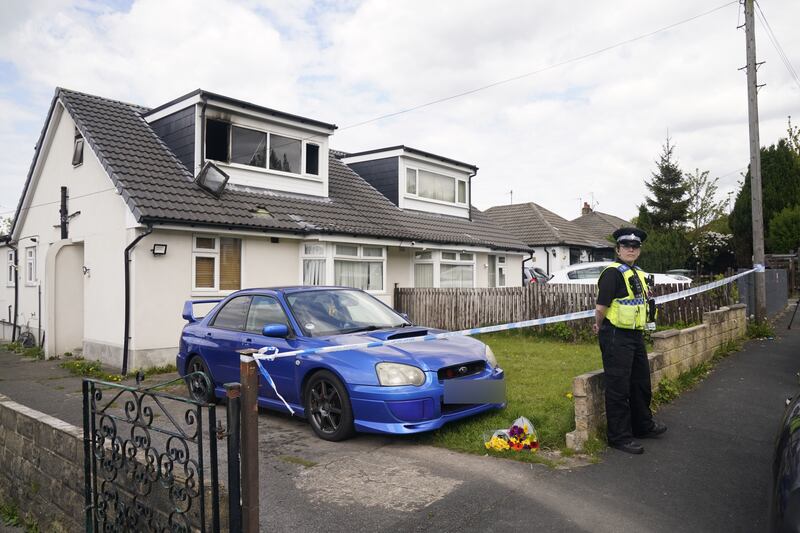 A police officer at the scene of the fatal house fire in Bradford