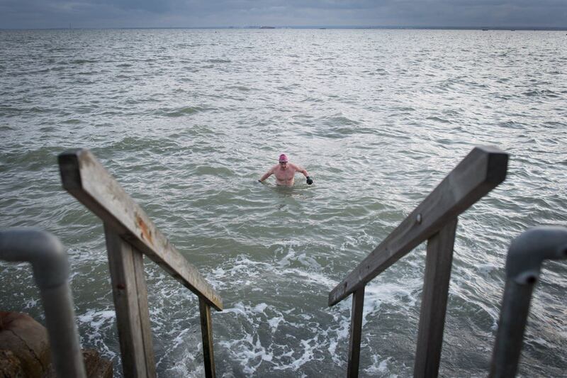 Swimmers take their daily dip in the Thames estuary at Leigh-on Sea in Essex