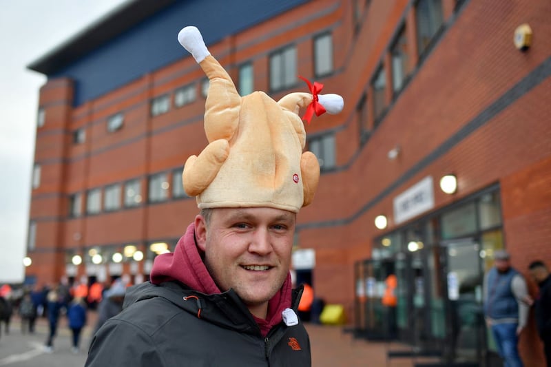 A fan arrives at the Hawthorns wearing a festive themed hat
