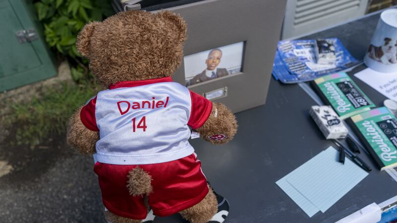 A teddy bear in a football jersey left as a tribute at a vigil at Hainault Underground station car park