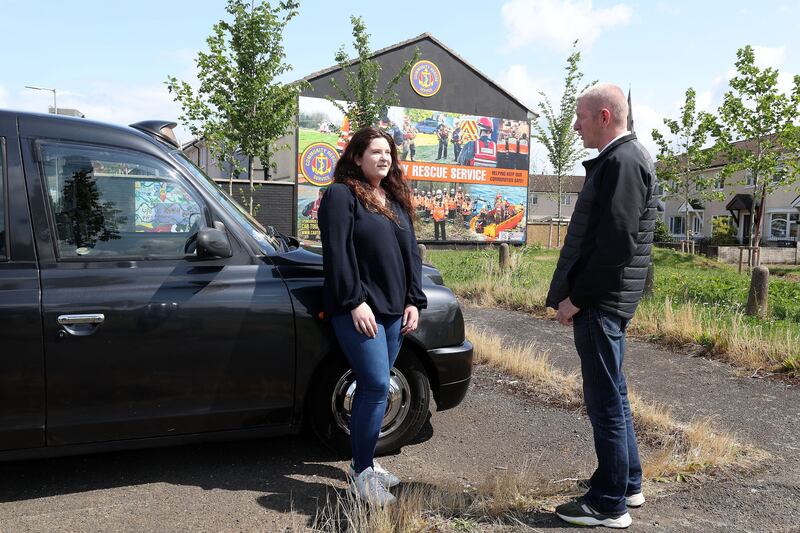Irish News journalist Sophie Clarke and Taxi Tour operator Thomas Campbell at the Community Rescue Service mural in the Shankill area. PIcture Mal McCann