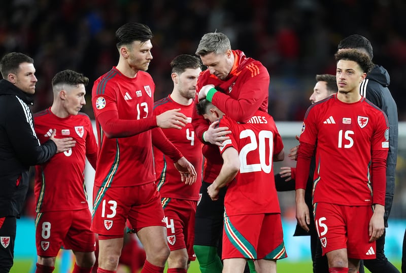 Wales players console Daniel James after his missed penalty against Poland