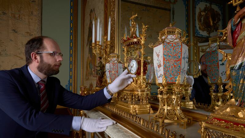A horological conservator adjustsa late-18th-century French mantelclock at Buckingham Palace