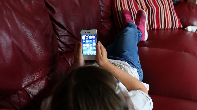 Generic stock photo of a child using an Apple iPhone smartphone (PA).