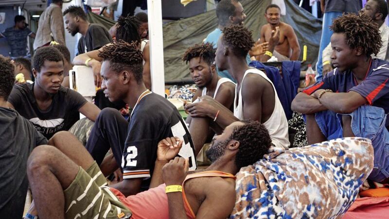 Migrants sit on the deck of the Open Arms vessel in front of island of Lampedusa, southern Italy Picture by Francisco Gentico/AP 