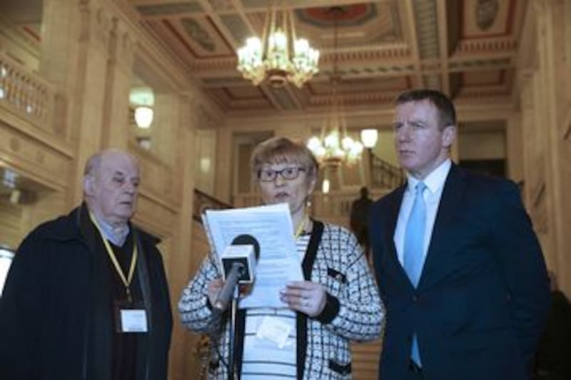 Breege Quinn reads a statement to the media today at Stormont accompanied by her husband Stephen (left) and SDLP MLA Justin McNulty. Picture by Hugh Russell&nbsp;