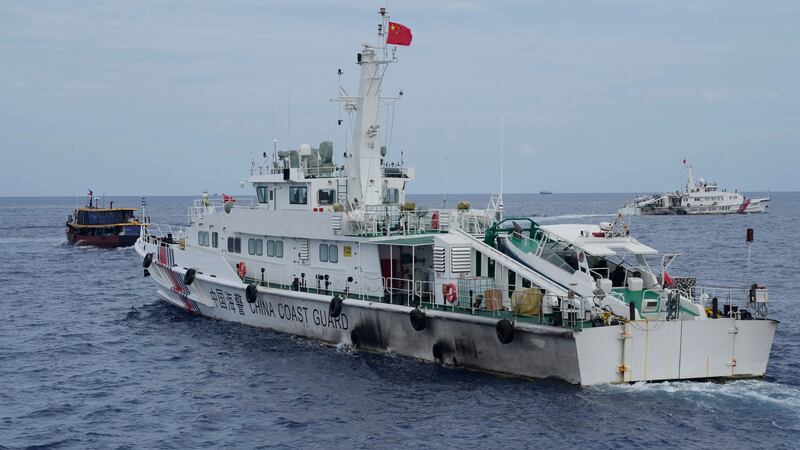 A Chinese coastguard ship tries to block the way of a Philippine supply boat, left, as it heads towards Second Thomas Shoal, locally known as Ayungin Shoal, in August (Aaron Favila/AP)