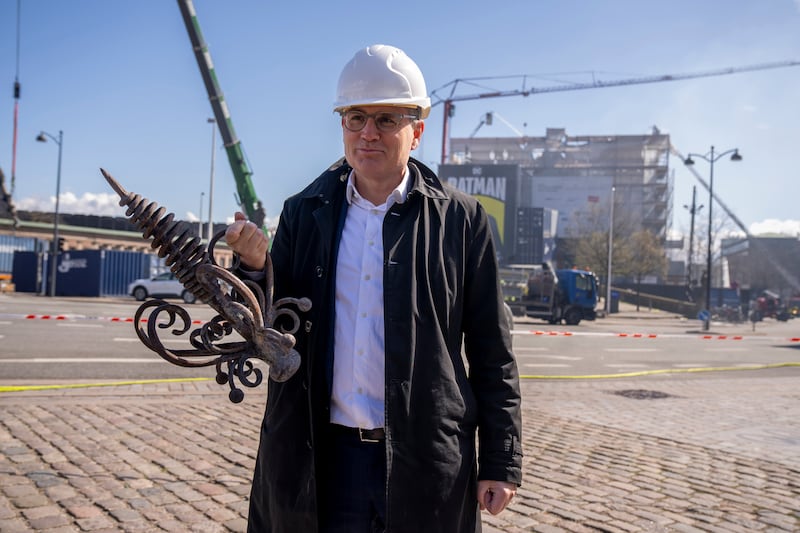 Danish Business CEO Brian Mikkelsen holds the top of the burnt dragon spire in front of Boersen (Ida Marie Odgaard/AP)