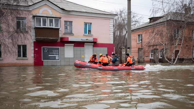 Emergency workers and police during evacuations in a flooded street after parts of a dam burst, in Orsk, Russia (AP)