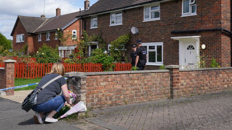 A person leaves flowers outside a property on Hammond Road in Woking, Surrey, where Sara Sharif was found dead (Jonathan Brady/PA)