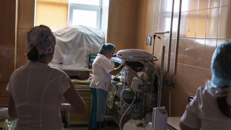 Misha, a baby born prematurely at 33 weeks, is checked on by staff in a room fortified with sandbags in the window at the Pokrovsk Perinatal Hospital, the only one under government control remaining equipped to care for premature babies, in Pokrovsk, Donetsk region, eastern Ukraine, Monday, Aug. 15, 2022 (AP Photo/David Goldman)