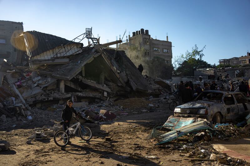 Palestinians search for bodies and survivors in the rubble of a residential building destroyed in an Israeli airstrike in Rafah, southern Gaza Strip, on Friday (Fatima Shbair/AP)