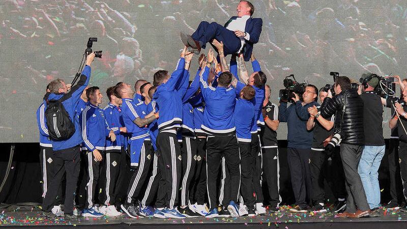 Northern Ireland players throw manager Michael O'Neill in the air as fans gathered at the Titanic Quarter to welcome the team home &nbsp;