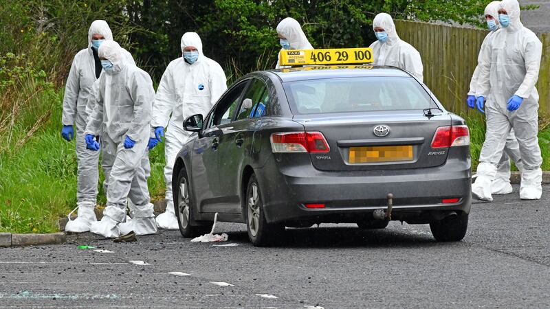 Police forensics officers pictured examining a taxi believed to be linked to the shooting incident in Banbridge last month. PICTURE: ALAN LEWIS